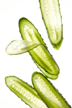 Beyaz arka planda izole edilmiş salatalık yeşili dilimler. Yaratıcı salatalık duvar kağıdı, yemek arkaplanı tasarımı