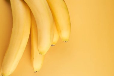 Sarı arkaplanda kopyalanmış muz sürüsü