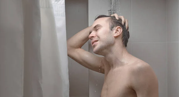 잘생긴 남자의 모습은 샤워기 클로즈업 화장실에서 샴푸로 머리를 — 스톡 사진