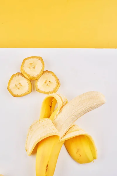 Plátano Medio Pelado Rodajas Sobre Fondo Blanco Amarillo Con Espacio — Foto de Stock