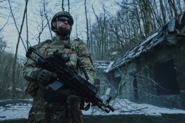 Ormanda makineli tüfekle profesyonel ekipman içinde uçan yumuşak oyuncunun portresi. Savaşta silahlı bir asker