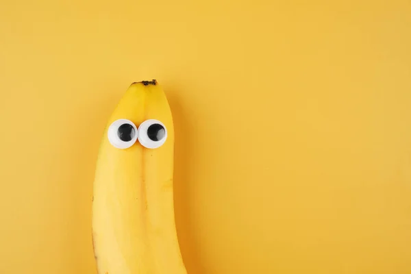 有趣的香蕉与眼睛概念隔离在黄色背景与复制空间 — 图库照片