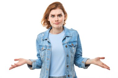 Şaşkınlık içindeki kızıl saçlı kız omuz silkiyor, sorgulayıcı bir jest yapıyor, cahil ve şaşkın bir görünüşü var, beyaz izole bir geçmişi olan bir kadın. Ne fark eder ki??