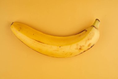 Kabuklu muz, sarı arkaplanda izole edilmiş. Kopya alanı, üst görünüm, kırpma yolu var.