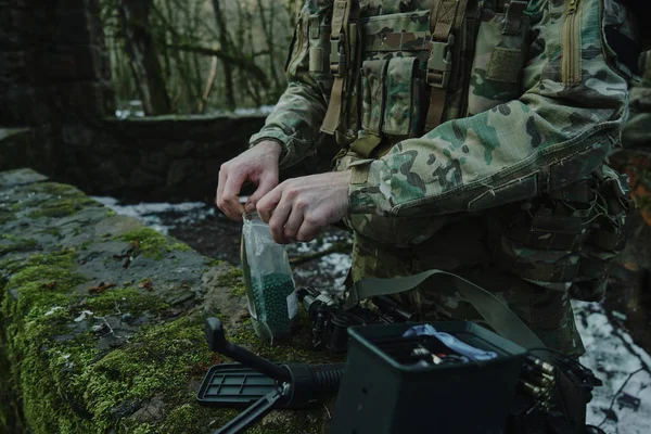 プロ仕様の航空ソフトプレーヤーの肖像は 森の中で弾丸と銃をロードします 戦争中の武器を持つ兵士 — ストック写真