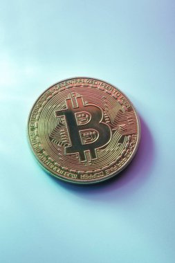 Mavi arkaplanda izole edilmiş bir altın bitcoin kopya alanı ile yakın plan