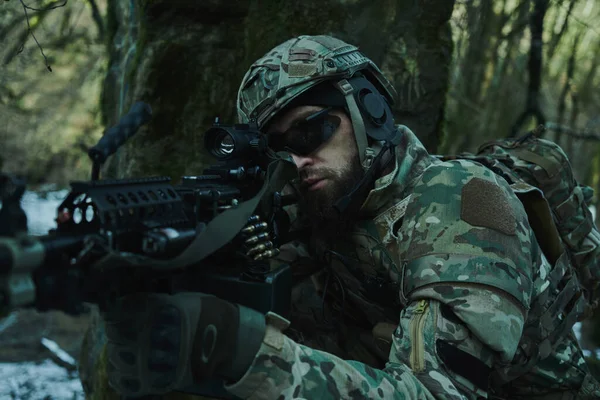 森の中の銃で犠牲者を目指してヘルメットのプロの機器でのエアソフトプレーヤーの肖像画 戦争中の武器を持つ兵士 — ストック写真