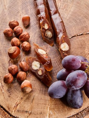 Kilise kilisesi, ulusal Gürcistan tatlısı üzüm suyu ve fındık ağacından yapılmış, ahşap bir masada kompozisyon.