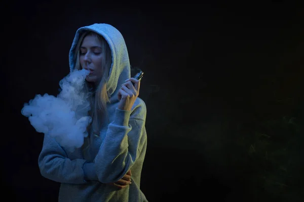 Portret Pięknej Blondynki Szarej Bluzie Kapturem Pali Vape Izolowane Czarnym — Zdjęcie stockowe