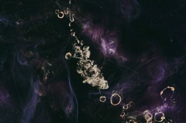 Abstract fluid art background. Moving flow of purple gold paints, dark space sky