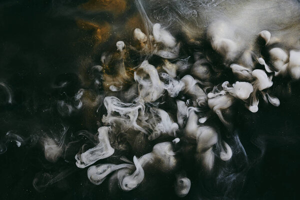 Абстрактный красочный дым, темный фон. Движущийся поток золотых черных красок, жидкое искусство, космическое небо