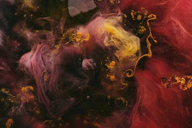 Soyut renkli duman, koyu arkaplan. Sarı ve kırmızı boya akışı, akışkan sanat