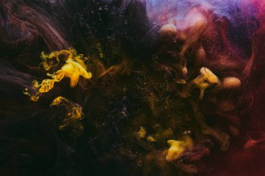 Soyut renkli duman, koyu arkaplan. Sarı ve kırmızı boya akışı, akışkan sanat