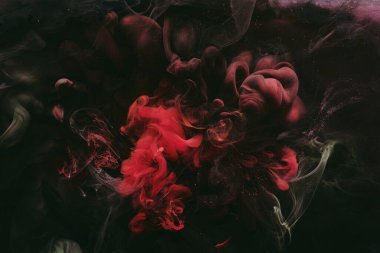 Soyut renkli duman, koyu arkaplan. Kırmızı boya akışı, akışkan sanat