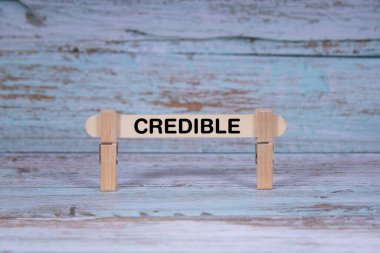 Tek tahta sopa kirli mavi arka planda mandallar tarafından sıkılmış iş ve güvenilir konsept taşıma.