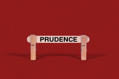 Güzel bir kırmızı zemin üzerinde mandallarla sıkıca tutulan tahta sopa iş ve ihtiyat kavramını temsil eder..