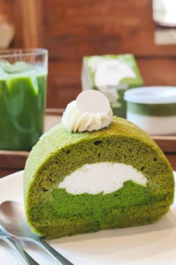 Ahşap masada kibrit yeşil çay rulosu kek