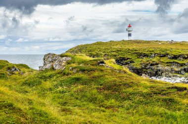 Lofotes 'daki deniz feneri dramatik bir gökyüzünün altında