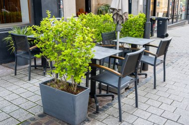 Cafe on the open air in Luxemburg. Chairs and tables outside with summer sun weather in France on the street. Design of furnitureset for summer cafe or restaurant.