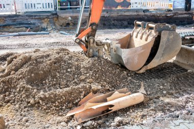 Büyük şehirdeki asfalt yolda tamir için buldozer kovası. Toprak hareket makinesi. Cadde tadilatı.