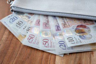 İngiliz sterlini parası olan gümüş bir parti. Ticaret konsepti için deri cüzdanda United Kindom faturaları.