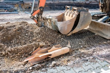 Büyük şehirdeki asfalt yolda tamir için buldozer kovası. Toprak hareket makinesi. Cadde tadilatı.