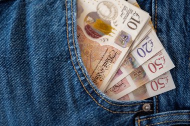 İngiliz parası olan kot pantolonlar. Ticaret konsepti için United Kindom faturaları pantolon cebinde..