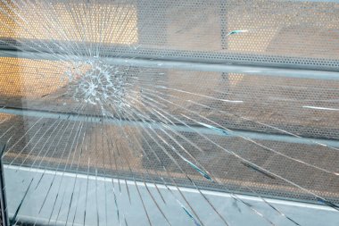 Yakın binada büyük ve küçük çatlaklar olan eski kırık camlar. Şehir caddesinin manzarası ve koruması olan kirli pencere..