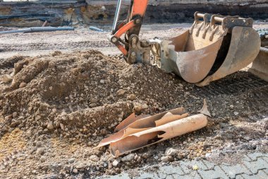 Büyük şehirdeki asfalt yolda tamir için buldozer kovası. Toprak hareket makinesi. Cadde tadilatı.
