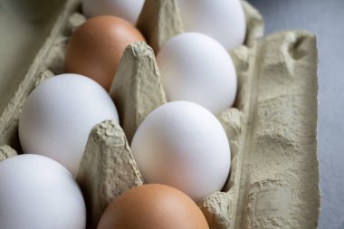 Beyaz ve kahverengi taze yumurtalar. Doğa geçmişi. Sağlıklı yemek pişirmek için karton kutuda tavuk yumurtası. Çiftlikteki biyoorganik yumurtalar. Yiyecek konsepti.