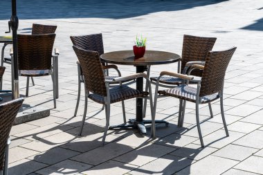 Almanya 'da açık havada bir kafe. Lüksemburg 'da yaz güneşi havası olan tahta sandalyeler ve masalar. Yaz kafesi veya restoranı için mobilya dizaynı.