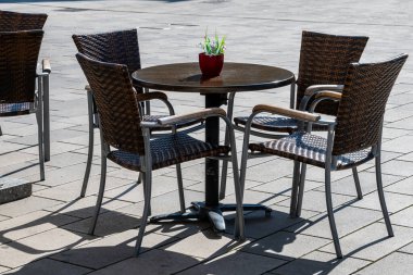 Almanya 'da açık havada bir kafe. Lüksemburg 'da yaz güneşi havası olan tahta sandalyeler ve masalar. Yaz kafesi veya restoranı için mobilya dizaynı.