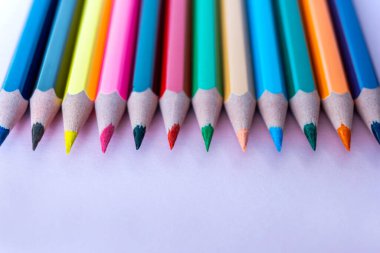 Kağıt arkaplanda çok renkli kalemler var. Kapatın. Eğitim ya da tasarım konsepti. Metin için yer.