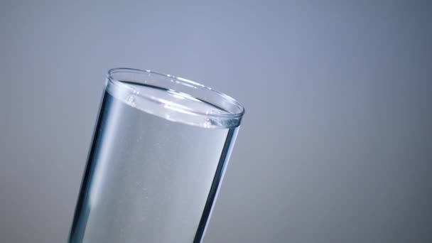 Goutte de glaçon dans un verre d'eau 