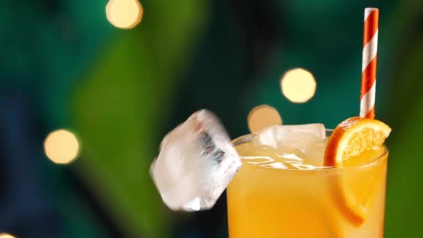 Ice Cube Splashing w tropikalnym napoju pomarańczowym — Wideo stockowe