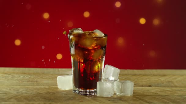 Ice Cube Splashing in Cola Soda on Rustic Wood Table — Stock Video