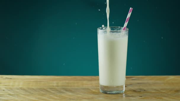 Espirro de leite em vidro na mesa de madeira — Vídeo de Stock