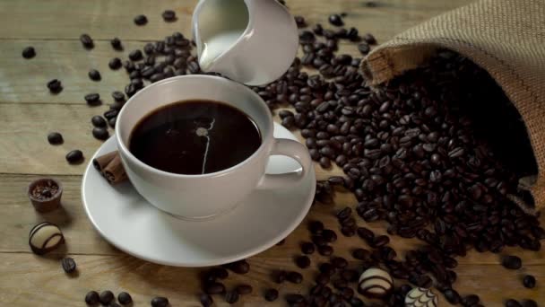Leite derramado em xícara de café quente em câmera lenta — Vídeo de Stock