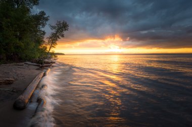Yaz aylarında bir göl kenarında turuncu günbatımı