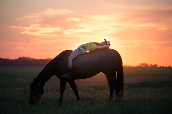 Girl lying on her horse bareback — Stock Photo, Image