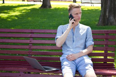 Genç adam bankta telefon ile
