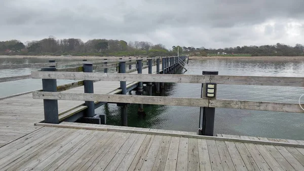 Gri su üzerinde uzanan ahşap iskele Rydeback