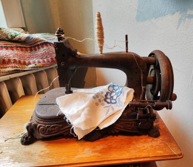 Beyaz işlemeli eski paslı metal dikiş makinesi.