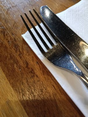 Çatal ve bıçak peçete çatalları üzerinde ahşap masa restoranının kafe barında garsonu boş servis ediyor. Yüksek kalite fotoğraf