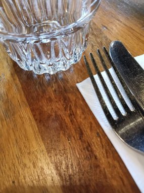 Çatal ve bıçak peçete çatalları üzerinde ahşap masa restoranının kafe barında garsonu boş servis ediyor. Yüksek kalite fotoğraf