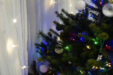 Süslü, bembeyaz takılar ve çok renkli ışıklarla süslenmiş yeni yıl ailelerinin sıcak atmosfer tatili kutlamaları. Yüksek kalite fotoğraf