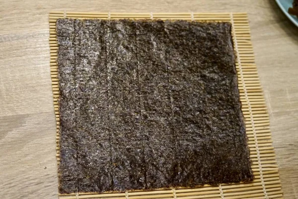 Suşi hasırında iki nori yaprağı hazır ahşap masa mutfağı geleneksel Japon mutfağı.