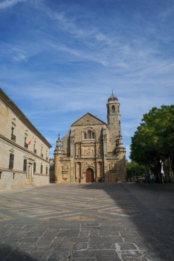 Sacra Capilla del Salvador 'un ana cephesi, güneşli bir sonbahar gününde, bir meydanda ve Beda şehrinin yanında.