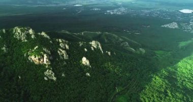 Resimli uçurumların ve şehrin dışındaki yeşil dağ yamaçlarının havadan görünüşü. Kuzey Kafkasya 'nın manzarası ve doğası.