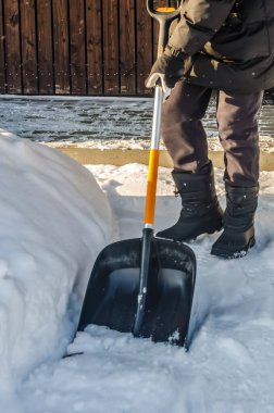 Kaldırımdan derin kar temizleyen birinin yakın çekimi. Parlak, güneşli bir günde kar fırtınasından sonra elle kar temizleme ve kış işleri yüksek kaliteli fotoğraf.